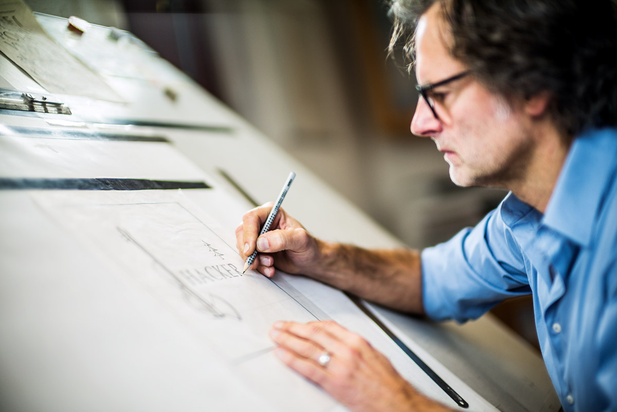 Am Zeichenbrett im Atelier entstehen dann exakte Vorlagen für Texte und ­Formen jedes individuellen Epitaphs.