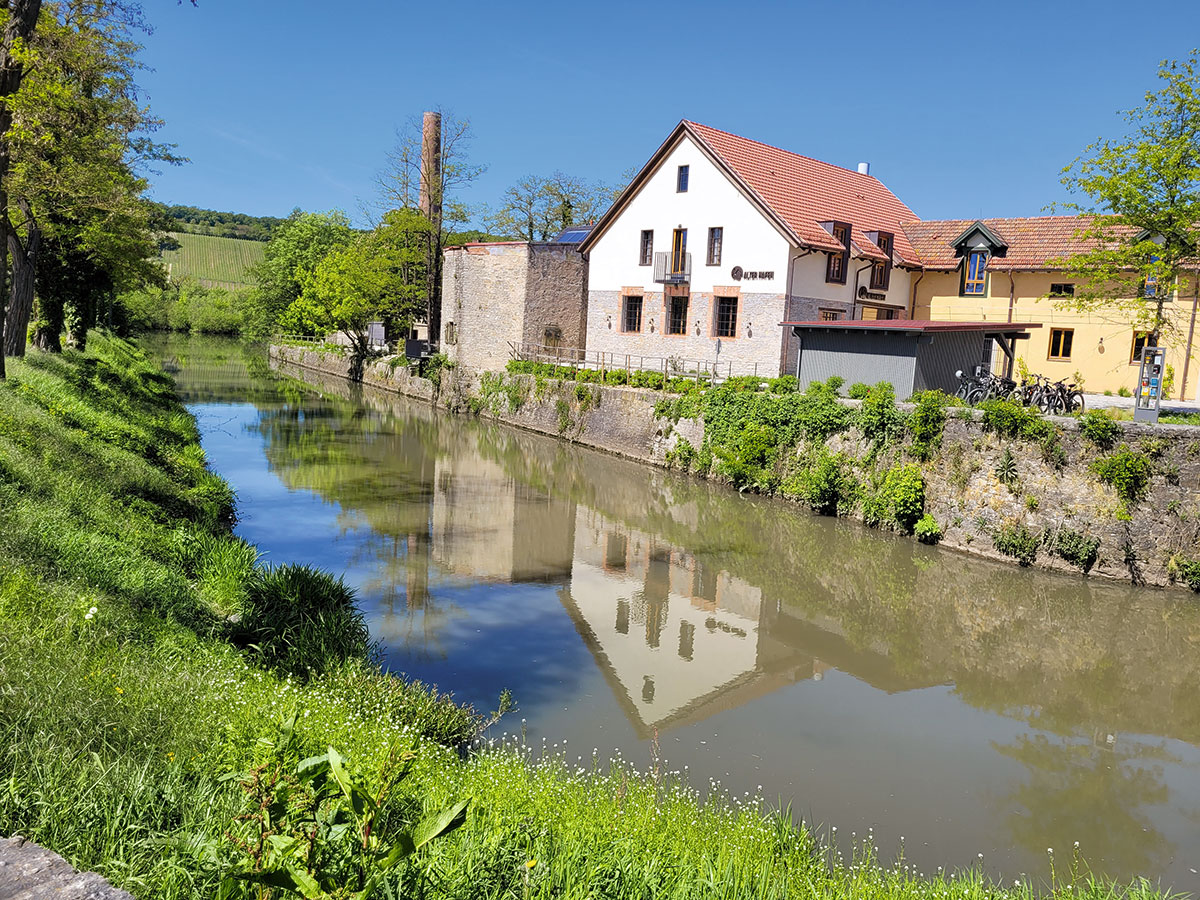 Bilden ein Denkmalensemble: das Städtchen Marktsteft und der Alte Hafen mit Ziegelschornstein, steinernem Kran-Sockel sowie ehemaligen Lager- und Fabrikgebäuden.
