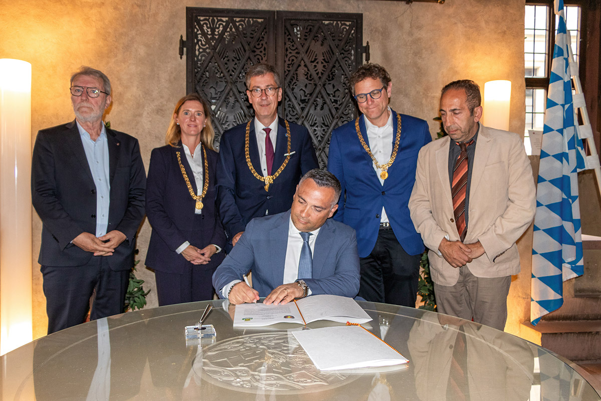 Alessandro Di Mauro, Präsident des Stadtrates von Siracusa, unterschreibt im Mai 2025 die Partnerschaftsurkunde. Hinten von links: Stadtrat Antonino Pecoraro, Bürgermeisterin Judith Roth-Jörg, Oberbürgermeister Christian Schuchardt, Bürgermeister Martin Heilig und Stadtrat Emanuele La Rosa. Foto: Christian Weiß