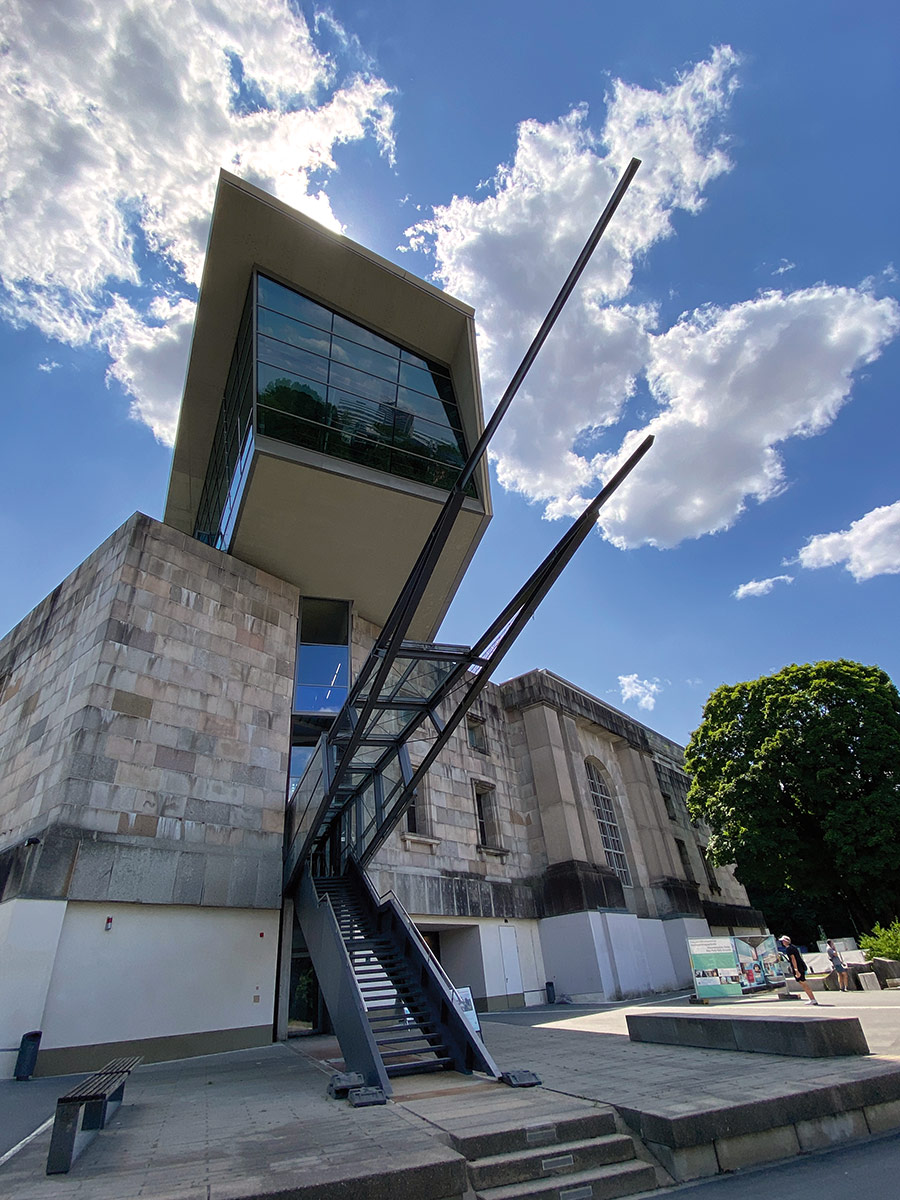 Der Eingangsbereich des Dokumentationszentrums Reichsparteitagsgelände im nördlichen Kopfbau der Kongresshalle. Der gläserne „Domenig’schen Pfahl“ durchtrennt die massige Bausubstanz und stört die rechtwinklige Geometrie des NS-Baus nachhaltig.
