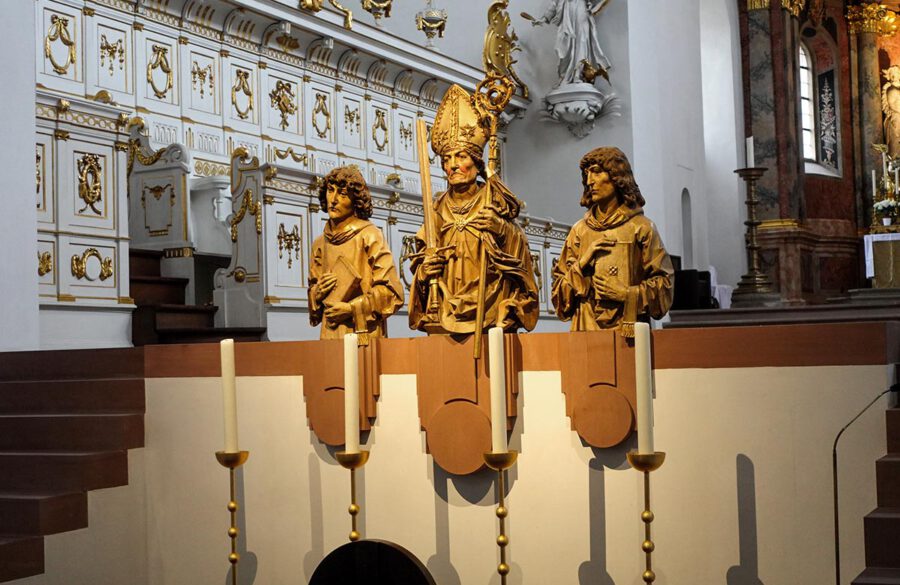 Würzburg, Neumünster: Die Mauer zum Hochchor schließen die Büsten der Frankenapostel Kilian (dargestellt als Bischof), Kolonat und Totnan ab. Die Figuren wurden 1910 von Heinz Schiestl nach den Vorbildern von Tilman Riemenschneider kopiert. Die Originalfiguren wurden 16. März 1945 ein Raub der Flammen. Würzburg, Neumünster: Die Mauer zum Hochchor schließen die Büsten der Frankenapostel Kilian (dargestellt als Bischof), Kolonat und Totnan ab. Die Figuren wurden 1910 von Heinz Schiestl nach den Vorbildern von Tilman Riemenschneider kopiert. Die Originalfiguren wurden 16. März 1945 ein Raub der Flammen.